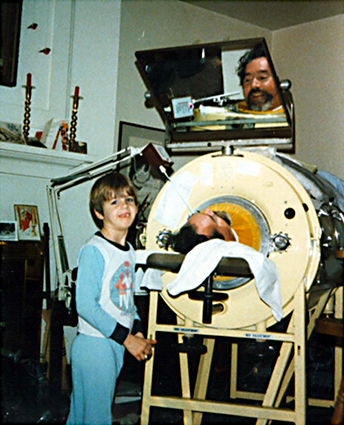 Ed Roberts, in an iron lung and with his son having a conversation.