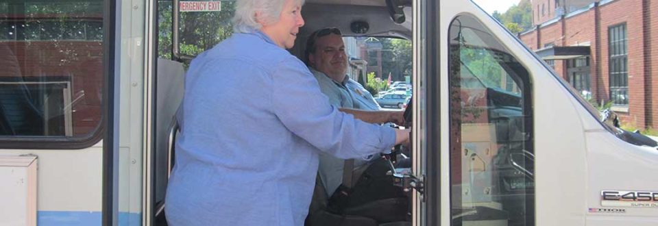 An older woman boards a bus